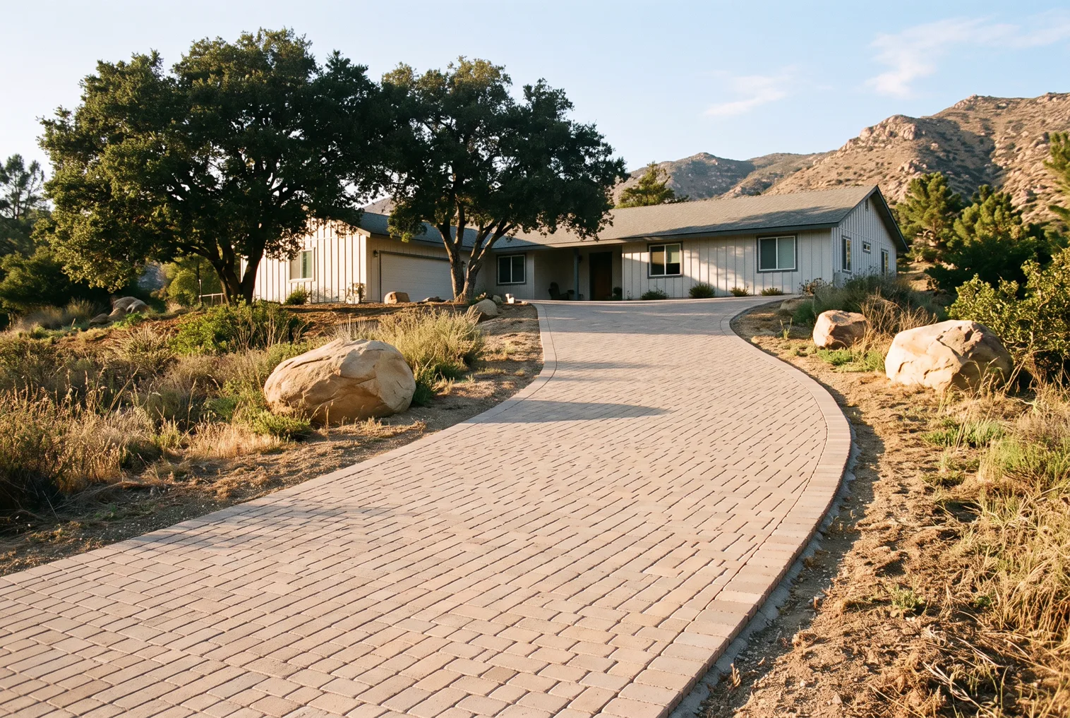 Design rendering of a paver driveway curving up to a single story ranch house in warm afternoon light
